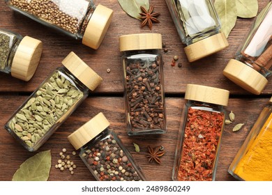 Different spices in glass jars on wooden table, flat lay - Powered by Shutterstock