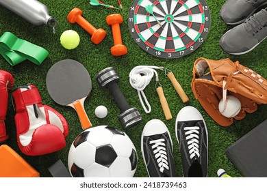 Different sport equipment and sneakers on green grass, flat lay - Powered by Shutterstock