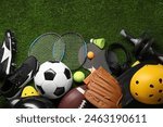 Different sports equipment on green grass, flat lay