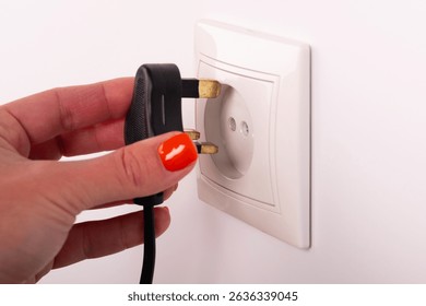 Different standards for electrical outlets. Unsuitable connector and plug in the hand of a person. Incompatibility, concept