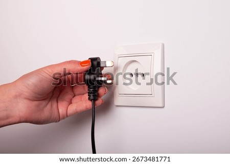 Different standards for electrical outlets. Unsuitable connector and plug in the hand of a person. Incompatibility, concept