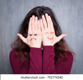 Different states of mood, woman covering her face with hands with drawn happy and sad 