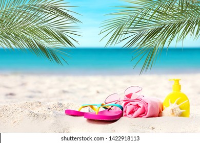 Different stylish beach accessories on sand near sea, space for text - Powered by Shutterstock