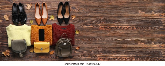 Different Stylish Shoes, Sweaters, Bags And Mobile Phone On Wooden Background With Space For Text. Black Friday Sale