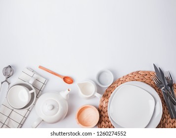 Different tableware and dishes on the white background, top view. Kitchen accessories flat lay.