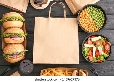 Different tasty food from delivery service on wooden background