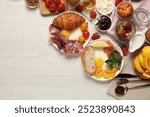 Different tasty food served for brunch on white wooden table, flat lay. Space for text