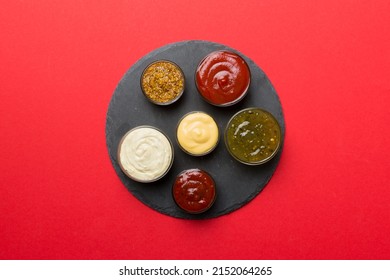 Different tasty sauces in bowls on plate on colored background. top view. - Shutterstock ID 2152064265