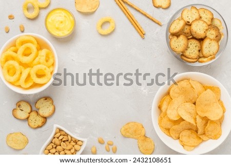 Different tasty snacks with sauce on concrete background, top view