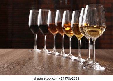 Different tasty wines in glasses on wooden table - Powered by Shutterstock