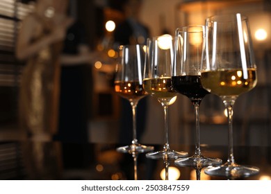 Different tasty wines in glasses on table indoors, selective focus