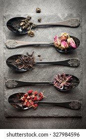 Different Tea And Dried Herbs In Vintage Spoon. Top View, Vertical
