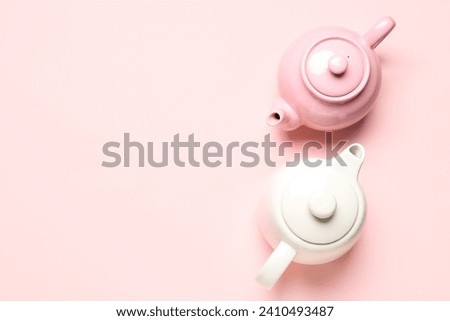Different teapots on pink background