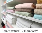 Different terry towels on shelves in linen shop