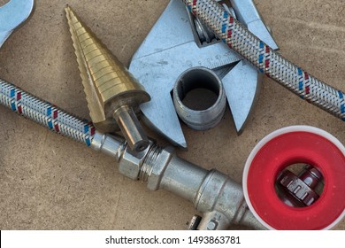 Different Things For Plumbers Lie On Ground. Teflon Tape, Wrench, Hose, Tube, Water Tap .