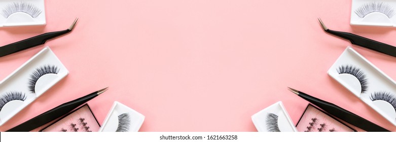 Different tools for eye lash extension on trendy pastel pink background. Fake eyelashes and tweezers. Beauty concept. Makeup cosmetics. Top view, flat lay. Layout. Place for text and design. Banner.