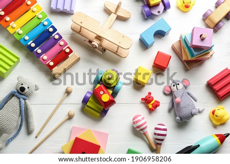 Different toys on white wooden background, flat lay
