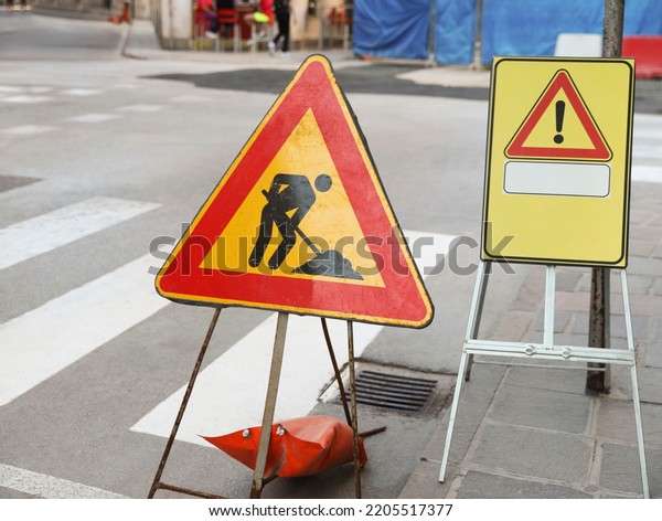 Different traffic signs near pedestrian crossing\
on city street