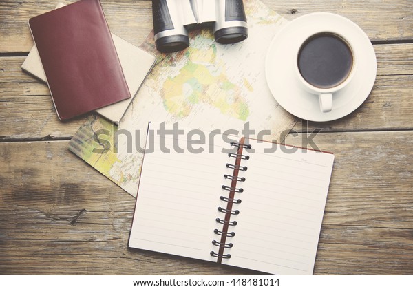 different travel\
items on map on wooden\
table
