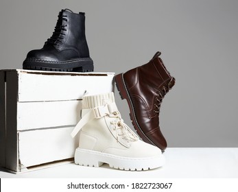 different Trendy boots with white wooden box. fashion shoes still life