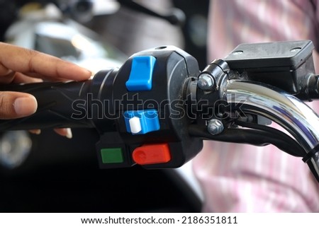 Different type of control switches on a bike handle or handlebar with hands touching them