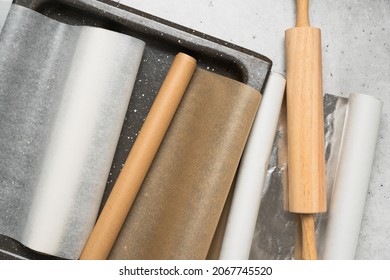 Different type of paper for baking needs. Parchment paper, foil, wax paper close up on grey stone background, flat lay