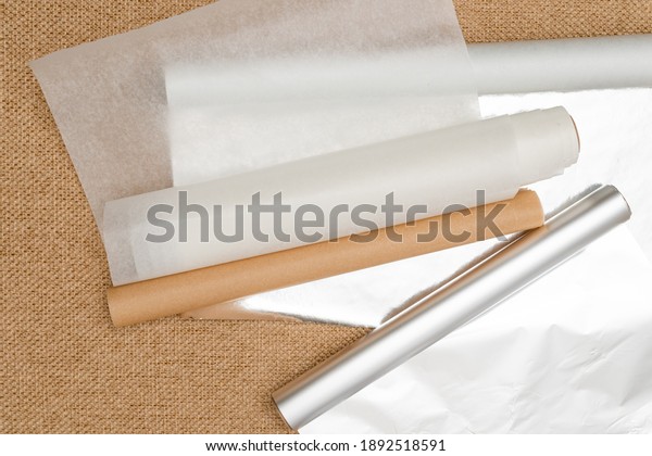 Different type of\
paper for baking needs. Parchment paper, foil, wax paper close up\
on rustic background, flat\
lay