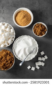 Different type of sugar, light brown, dark brown and white sugar cubes in bowls. 