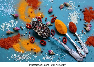 Different Types Of Aromatic Herbs And Spices On Vibrant Blue Background. Colorful Picture Of Paprika, Turmeric Powder, Garlic, Clove, Pepper And Rose. Natural Antioxidants Concept. 