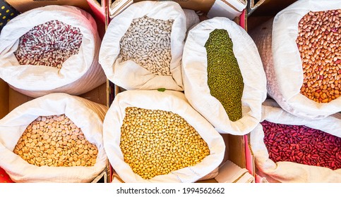 Different types of beans of various colors and lupins in bags for sale in bulk at a local flea market grown in nearby orchards