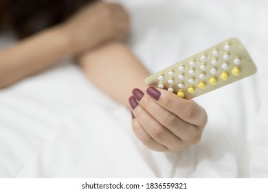Different types of birth control pills in the hands of women