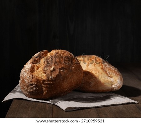 Different types of bread loaves on wooden table, closeup