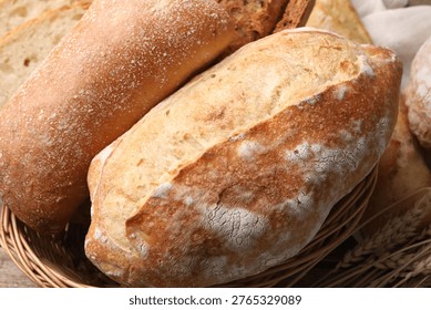 Different types of bread and wheat spikes on table, flat lay