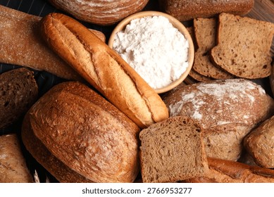 Different types of bread and wheat spikes on table, flat lay