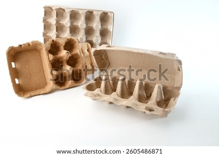 Different types of cardboard egg cartons arranged on a white background. Open, closed, and lidless designs showcase variations in egg packaging. raw craft material for kids project and DIY process
