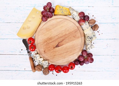 Different Types Of Cheese With Empty Board On Table Close-up