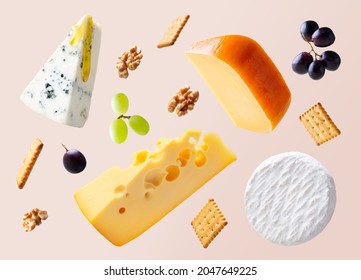 Different types of cheese are flying or falling in the air. Levitation concept. Cheeses mix maasdam, dor blue, camembert, brie and grapes, walnuts, galeta. Isolated. Copy space. - Shutterstock ID 2047649225