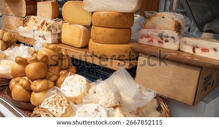 Different types of cheese wheels and blocks on a wooden stall at local farmers market Traditional dairy products and gourmet food concept