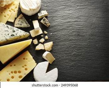Different types of cheeses on black board. - Shutterstock ID 249395068