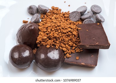 Different types of chocolate and nstant coffee on a white plate