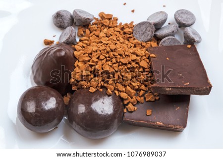 Different types of chocolate and nstant coffee on a white plate