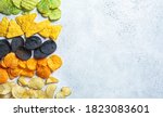 Different types of colored potato chips, gray background. Fast food concept, unhealthy fatty carbohydrate food.
