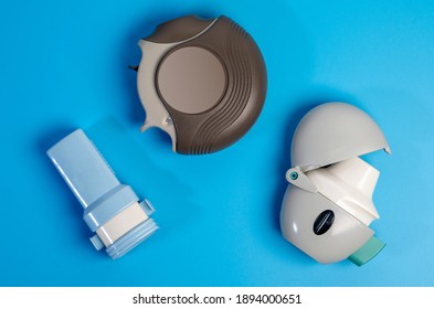 Different Types Of COPD Or Asthma Medication Instruments ,discus And Handihaler And A Capsule Inhaler.On Blue Background.