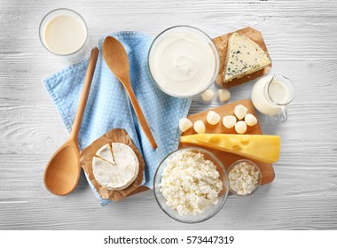Different types of dairy products on wooden background - Shutterstock ID 573447319