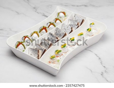 Different types of  Delicious Indian sweets. Made up of Mawa, Milk, and Sugar. isolated on a marble background.