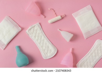 Different types of feminine menstrual hygiene materials products such as pads cloths tampons and cups. Pink background. Menstruation and feminine hygiene concept.
