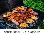 Different types of grilled meat on charcoal grill.