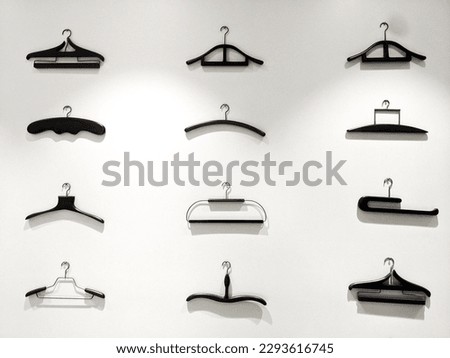 different types of hangers kept on a white wall tailoring material hanger for cloths