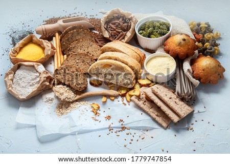 Different types of high carbohydrate food. Selection of good sources of carbs on grey background. 