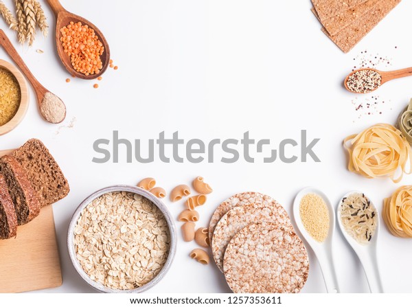 Different types of high carbohydrate food.\
Flour, bread, dry pasta and lentils and other ingredients on the\
white background.